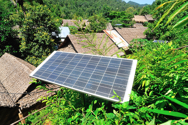 mini grid solar panel in jungle treetops and roofs