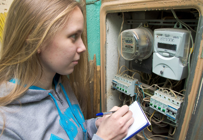 young lady with blonde hair, taking a meter reading