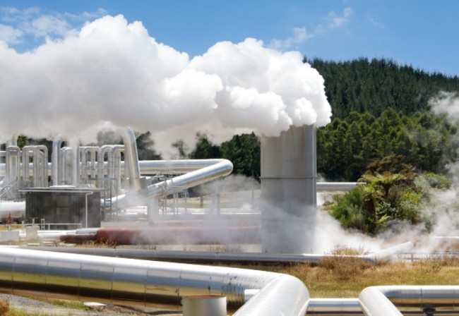 close up of geothermal plant with steam billowing